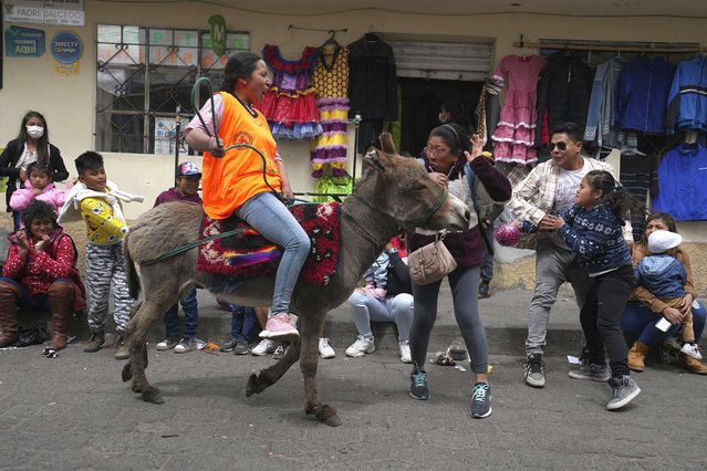 Spectators react as a competitor races past in the annual donkey festival in Salcedo, Ecuador, Saturday, September 10, 2022. (Photo by Dolores Ochoa/AP Photo)