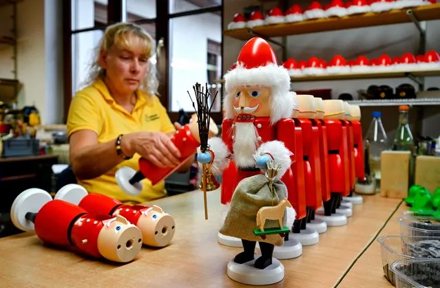 An employee assembles nutcrackers at the workshop of wood art manufacturer Seiffener Volkskunst in Seiffen, Germany on September 14, 2022. (Photo by Matthias Rietschel/Reuters)