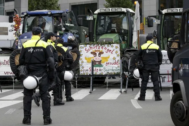Belgian riot police officers stand guard as farmers and dairy farmers from all over Europe take part in a demonstration outside an European Union farm ministers emergency meeting at the EU Council headquarters in Brussels, Belgium, September 7, 2015. (Photo by Jacky Naegelen/Reuters)