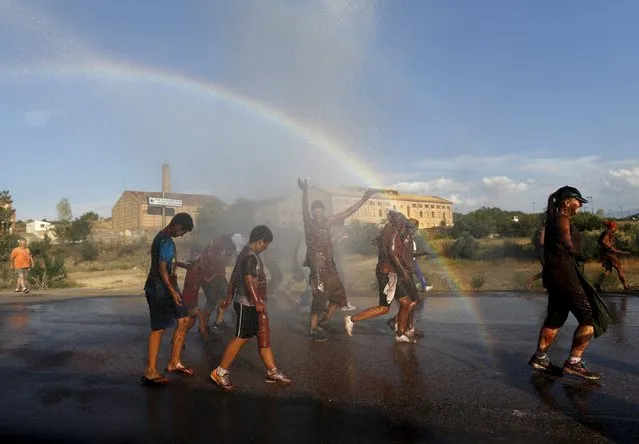 A rainbow forms as revellers covered in paint are sprayed with water during the annual Cascamorras festival in Guadix, southern Spain September 9, 2015. (Photo by Marcelo del Pozo/Reuters)
