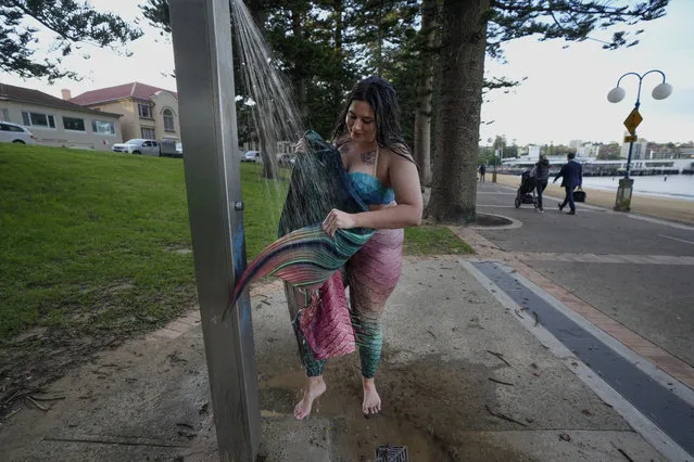 Lauren Metzler, founder of Sydney Mermaids, washes her tail after a swim at Manly Cove Beach in Sydney, Australia, Thursday, May 26, 2022. Across the world, people are increasingly embracing the subculture of “mermaiding”. At its simplest, these are humans of all genders, shapes and backgrounds who enjoy dressing up as mermaids. (Photo by Mark Baker/AP Photo)