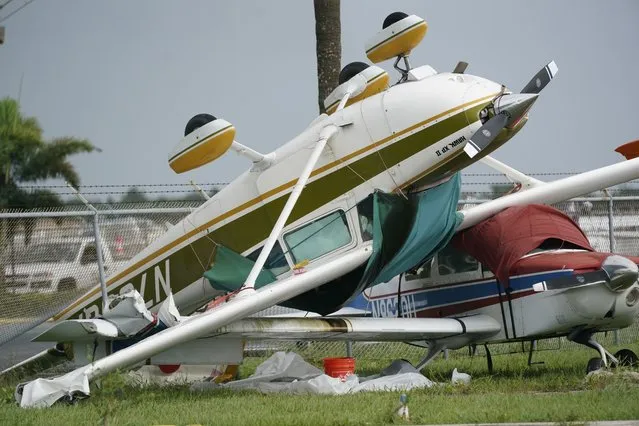 An airplane overturned by a likely tornado produced by the outer bands of Hurricane Ian is shown, Wednesday, September 28, 2022, at North Perry Airport in Pembroke Pines, Fla. Hurricane Ian rapidly intensified as it neared landfall along Florida's southwest coast Wednesday morning, gaining top winds of 155 mph (250 kph), just shy of the most dangerous Category 5 status. (Photo by Wilfredo Lee/AP Photo)
