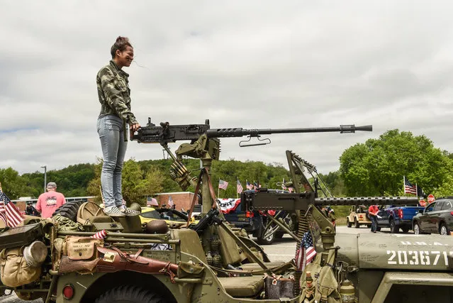 A girl stands on top of a jeep holding a large weapon before participating in a car parade for Memorial Day on May 25, 2020 in Carmel, New York. Participants planned to honor those who died while serving in the military and show support for the reopening of Putnam county during the Covid-19 pandemic. (Photo by Stephanie Keith/Getty Images)