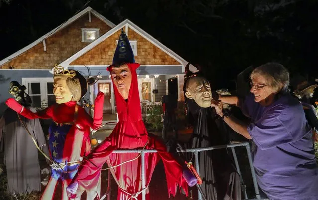 Homeowner Gail Douglas adjusts a likeness of Russian leader Vladimir Putin (R) standing next to US President Donald Trump (C), and Hillary Clinton (L) at her Halloween decorated home in Avondale Estates, Georgia, USA, 28 October 2017. Halloween spending the US is expected to reach 9.1 billion US dollars, according to the National Retail Federation. (Photo by Erik S. Lesser/EPA/EFE)