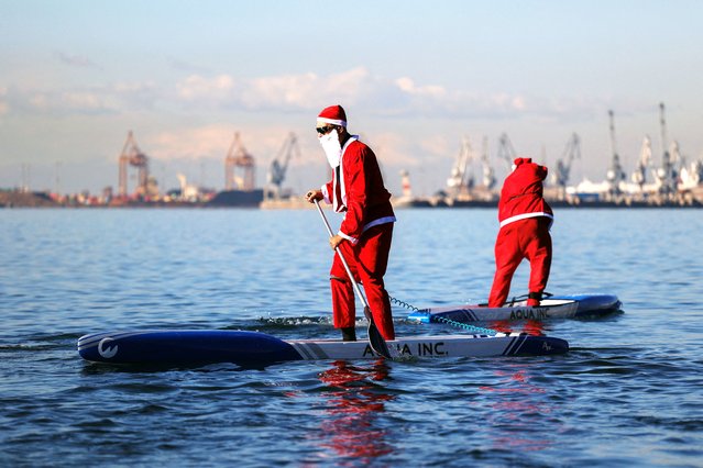 A member of the ThesSUP team dressed as Santa Claus paddles off the seafront of Thessaloniki, Greece on December 23, 2023. (Photo by Alexandros Avramidis/Reuters)