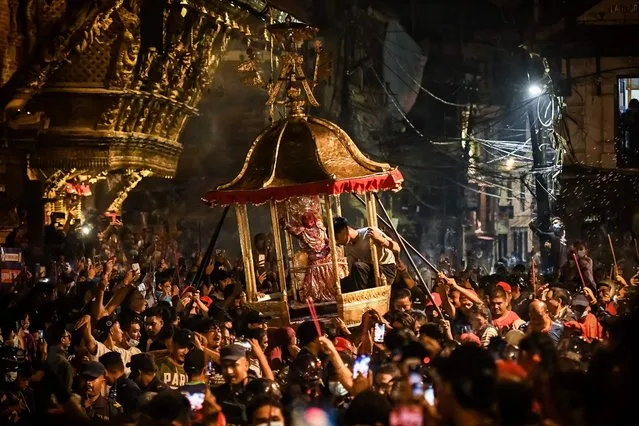 Devotees carry a chariot with Hindu God Bhimshen through Durbar square during the “Bhimsen Jatra” festival in Lalitpur on August 20, 2022. (Photo by Prakash Mathema/AFP Photo)