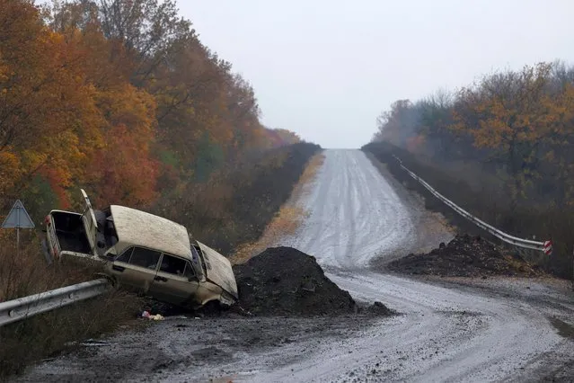 A destroyed car is seen on the main road, as Russia's invasion of Ukraine continues, in the eastern Donbas region of Bakhmut, Ukraine on October 30, 2022. (Photo by Clodagh Kilcoyne/Reuters)