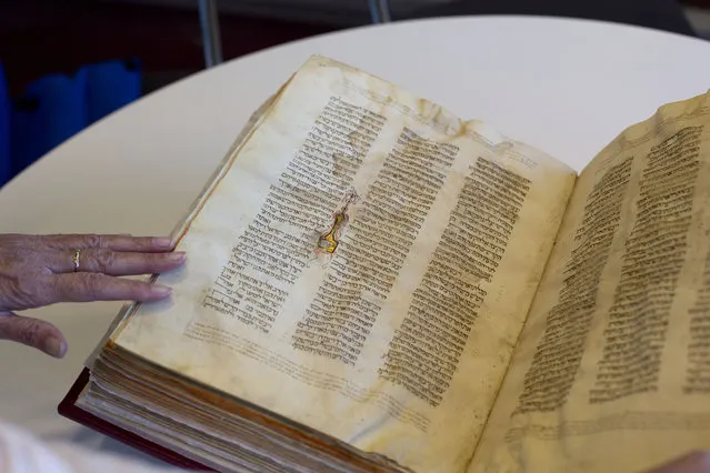 In this photo taken Sunday, October 5, 2014, a library official shows a Jewish manuscript smuggled into Israel from Damascus in a Mossad spy operation in the early 1990s, in Jerusalem. (Photo by Sebastian Scheiner/AP Photo)