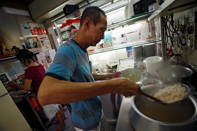 Hawker Lim Swee Heng prepares a bowl of laksa noodles, at Roxy Laksa stall, at the East Coast Lagoon Food Village in Singapore August 8, 2016. “It takes years to get the right balance to the broth, to make it thick just add coconut, to make it watery just add water, but to go in-between, to get that right balance – that's the hard work of my dish”. (Photo by Edgar Su/Reuters)