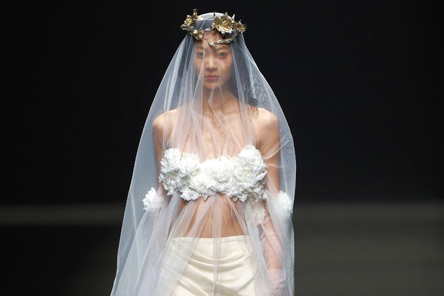 A model wears the latest fashion from Huqiu Bridal City during China Fashion Week in Beijing, Friday, March 21, 2025. (Photo by Ng Han Guan/AP Photo)
