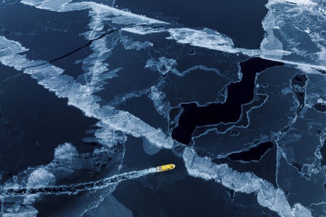 A boat rides though a frozen sea inlet outside of Nuuk, Greenland, Thursday, March 6, 2025. (Photo by Evgeniy Maloletka/AP Photo)