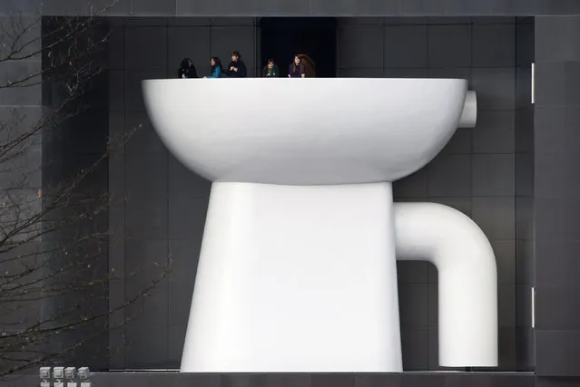Employees of German bathroom ceramic and furniture firm Duravit stand outside on a balcony atop of a giant lavatory bowl, at their company headquarters in Hornberg in the Black Forest, Germany, January 22, 2010. (Photo by Vincent Kessler/Reuters)