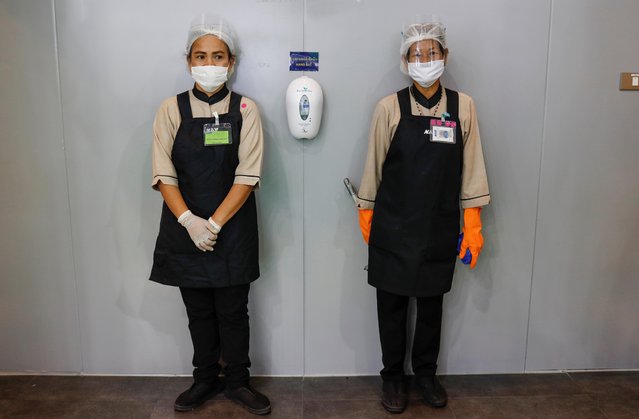 Staff members wearing face masks stand next to a toilet during the 41st Bangkok International Motor Show after the Thai government eased measures to prevent the spread of the coronavirus disease (COVID-19) in Bangkok, Thailand, July 15, 2020. (Photo by Jorge Silva/Reuters)