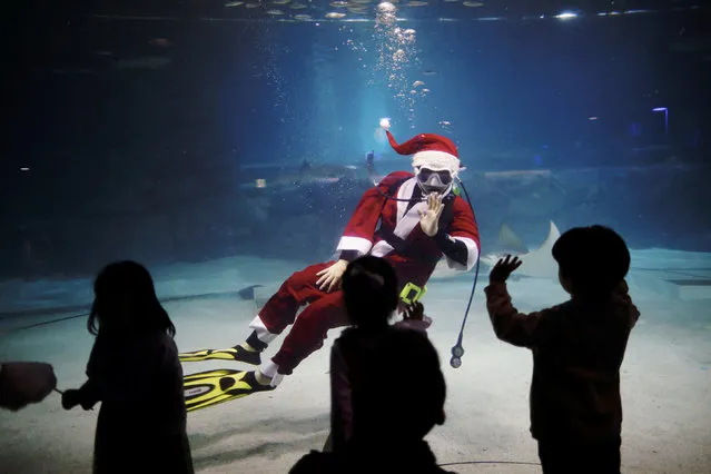 Children look at a diver dressed in a Santa Claus costume during a promotional event for Christmas “Sardines Feeding Show with Santa Claus” at the Coex Aquarium in Seoul, South Korea, December 10, 2017. (Photo by Kim Hong-Ji/Reuters)