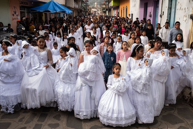 A group of girls dressed in white and carrying a baby Jesus walk in the streets during the traditional “Three Wise Men Parade” on January 6, in Miahuatlan, Mexico. Every year the residents of the Miahuatlan municipality organize a parade where kids get down the streets dressed as “Melchor, Gaspar, and Baltazar”, which are the names given to the wise men in some regions of Latin America. (Photo by Hector Quintanar/Getty Images)