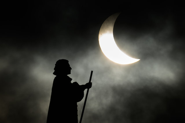 The statue of Dano-Norwegian Lutheran missionary Hans Egede is silhouetted during a partial solar eclipse on March 29, 2025 in Nuuk, Greenland. (Photo by Leon Neal/Getty Images)