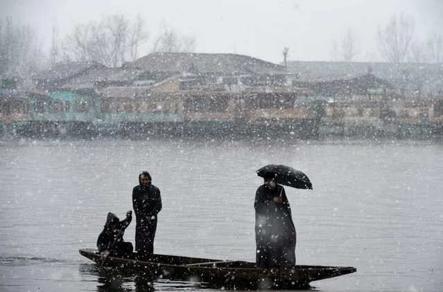 A Kashmiri Muslim men ride a Shikara boat during a snowfall at Dal lake in Srinagar on December 13, 2017. (Photo by Tauseef Mustafa/AFP Photo)