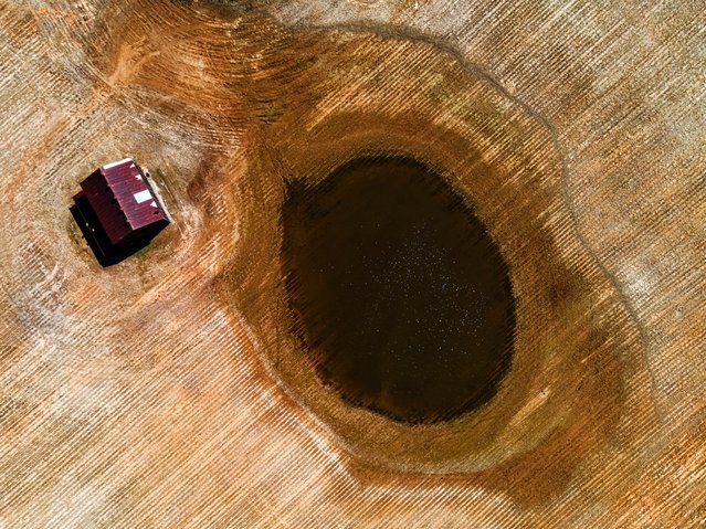 In an aerial view, a flooded section of farmland is seen next to a home in Cadiz, Kentucky, U.S. April 18, 2025. (Photo by Jon Cherry/Reuters)