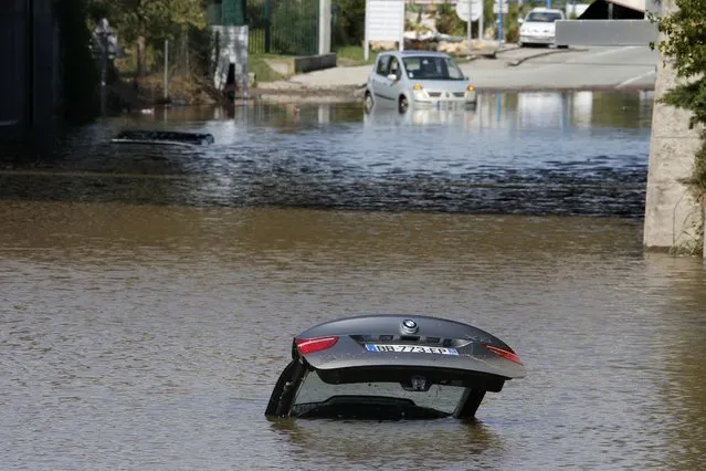 An abandoned car is submerged in deep water near by an underpass after flooding caused by torrential rain in Mandelieu, France, October 4, 2015. (Photo by Eric Gaillard/Reuters)