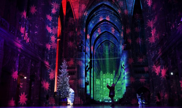 A visitor takes pictures of “The Light Before Christmas: The Angels Are Coming!” Light art installation during a press preview at the Anglican Cathedral in Liverpool, Britain, December 1, 2022. (Photo by Phil Noble/Reuters)