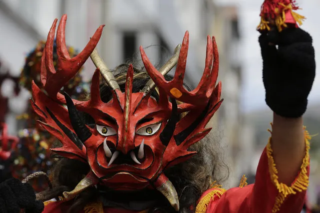 A man wearing a devil mask takes part in a parade as part of the traditional New Year's festival known as “La Diablada”, in Pillaro, Ecuador, Friday, January 5, 2018. (Photo by Dolores Ochoa/AP Photo)