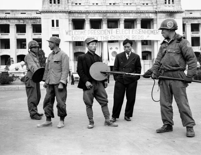 ROK soldiers search Korean workers as they enter the Capitol building grounds in Seoul, South Korea, November 30, 1952. All those entering to work are given this going over as U.S. President-elect Eisenhower is expected to visit. (Photo by George Sweers/AP Photo)
