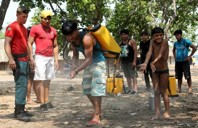 Firefighters and members of indigenous tribes attend a training at the Kamayura tribe, to combat wildfire in the Xingu National Park, Mato Grosso, Brazil, October 4, 2015. Brazilian firefighters from the Alianaca da Terra, a Civil Society Organization of Public Interest (OSCIP) that was trained by the U.S. Forest Service, are teaching indigenous peoples from 12 tribes in the Xingu National Park to prevent and combat wildfires in the Amazon forest. (Photo by Paulo Whitaker/Reuters)