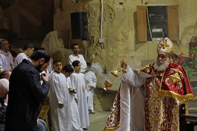 An Egyptian Coptic Priest leads the Christmas mass at the Saint Simon Monastery, also known as the Cave Church, in the Mokattam mountain of Egypt's capital Cairo on January 6, 2023. (Photo by Khaled Desouki/AFP Photo)