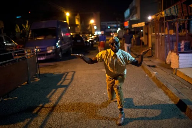 DJ Evans Mireku Kissi dances in the street outside the Republic Bar, Accra, Ghana, June 10, 2015. (Photo by Francis Kokoroko/Reuters)