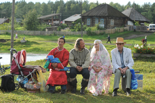 Followers of “Vissarion the Teacher”, or “Jesus of Siberia”, Russian ex-traffic cop Sergei Torop sit on a bench in the remote village of Petropavlovka on August 17, 2009. For thousands of followers, Vissarion is no less than the second coming of Jesus of Nazareth, reincarnated 2,000 years after his crucifixion, deep in the Siberian wilderness. (Photo by Alexander Nemenov/AFP Photo)