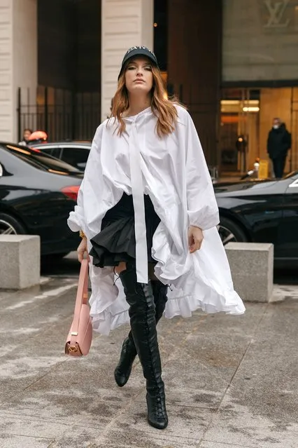 French actress and model Camille Razat wears white oversized blouse, black ruffled short mini skirt, bucket hat with logo print, rose pink bag, over knees boots high heel bootsoutside Patou at La Samaritaine on January 27, 2023 in Paris, France. (Photo by Tonya Matyu)