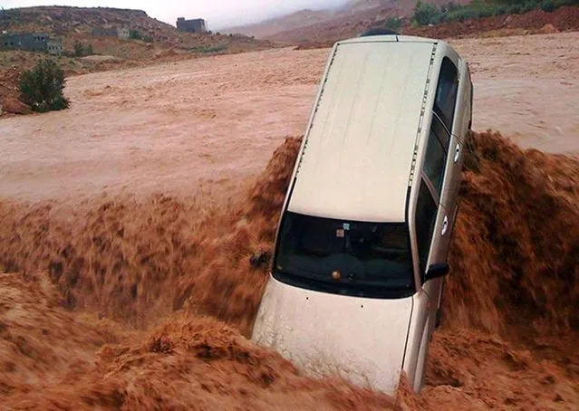 A car is carried away by flood waters November 23, 2014 in the southern region of  Ouarzazate in Morocco.  At least eight people were killed and 24 were missing as heavy storms lashed southern Morocco, causing flash floods, the authorities said. Flash floods are common in Morocco, where four children drowned in the south in September when they were swept away. (Photo by AFP Photo)