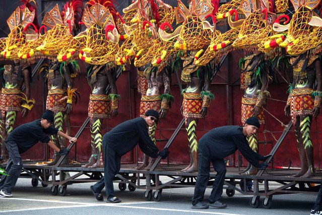 Workers push a trolley loaded with mannequins dressed in indigenous costumes during the 127th Independence Day celebration at Quirino Grandstand in Manila on June 12, 2025. (Photo by Ted Aljibe/AFP Photo)