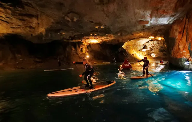 Competitors paddle during a Stand Up Paddle (SUP) race of the Alpine Lakes Tour, on Europe's biggest underground lake, in St-Leonard, Switzerland, March 10, 2018. (Photo by Denis Balibouse/Reuters)