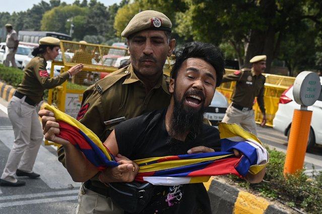 An activist of the Tibetan Youth Congress gets detained by security personnel outside the Chinese embassy during a protest against the visit of China's Minister of Foreign Affairs Qin Gang to attend the G20 foreign ministers' meeting, in New Delhi on March 1, 2023. (Photo by Money Sharma/AFP Photo)