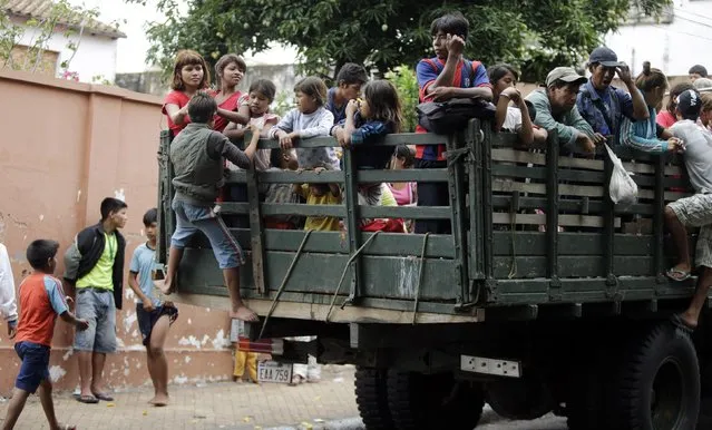 Members of the indigenous community Guarani sit in a military truck as they are sent back to Caaguazu, in Asuncion December 18, 2014. (Photo by Jorge Adorno/Reuters)