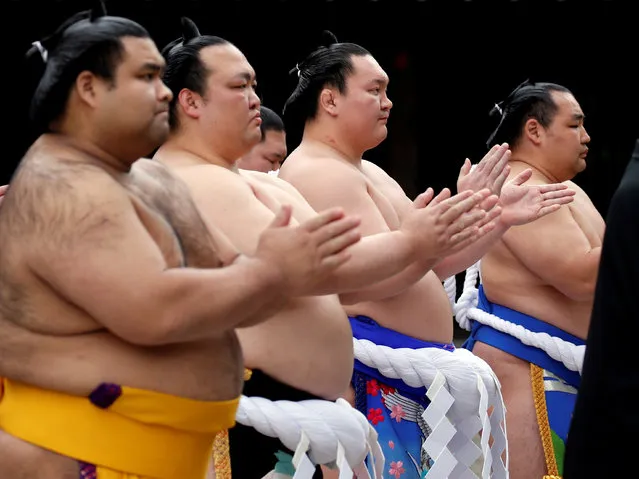 Mongolian-born grand sumo champion Yokozuna Kakuryu and Hakuho, Japanese grand sumo champion Yokozuna Kisenosato, and sumo champion Takayasu clap their hands as they pray during a ritual ceremony at the start of an annual sumo tournament dedicated to the Yasukuni Shrine in Tokyo, Japan on April 16, 2018. (Photo by Toru Hanai/Reuters)