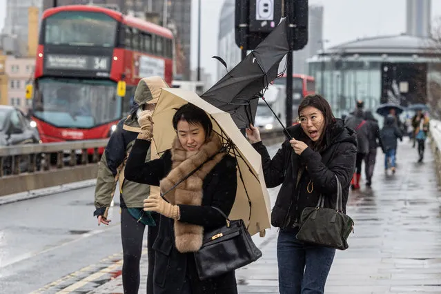 Despite the mild 14°С shoppers and commuters battle against the wind and rain on Waterloo Bridge, London on December 28, 2022. (Photo by Alex Lentati/London News Pictures)