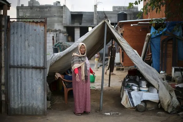 A Palestinian woman, whose house was destroyed by what witnesses said was Israeli shelling during a 50-day war in the summer of 2014, gestures outside her makeshift shelter on a rainy day, in Khan Younis in the southern Gaza Strip October 8, 2015. (Photo by Ibraheem Abu Mustafa/Reuters)