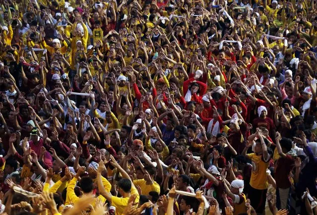 Devotees raise their hands as they pray before the start of the annual procession of the Black Nazarene in Manila, January 9, 2015. (Photo by Erik De Castro/Reuters)
