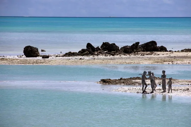 Young boys cover each other in reef-mud near the village of Ambo on South Tarawa in the central Pacific island nation of Kiribati May 25, 2013. (Photo by David Gray/Reuters)