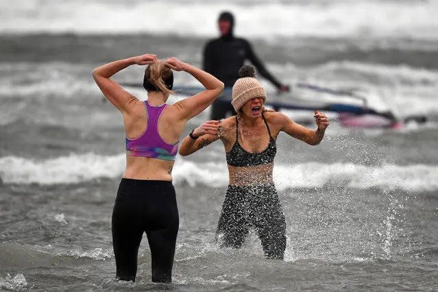Members of the public take to the water at Barassie Beach in Troon, on the west coast of Scotland on Boxing Day, December 26, 2020 as Storm Bella brings rain and high winds to the UK. (Photo by Andy Buchanan/AFP Photo)
