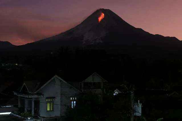 Lava spews out of Mount Merapi, Indonesia's most active volcano, as seen from the Kaliurang Selatan village in Srumbung, Magelang, Central Java on March 12, 2023. (Photo by Devi Rahman/AFP Photo)