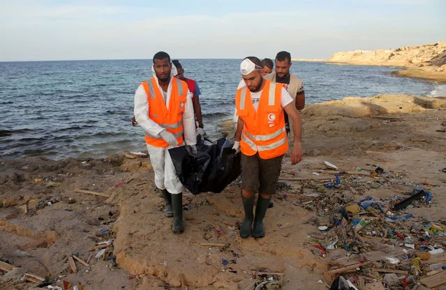 Rescue workers carry a bag containing the dead body of a migrant which washed ashore, in Tripoli's Janzour city, Libya November 5, 2016. (Photo by Hani Amara/Reuters)