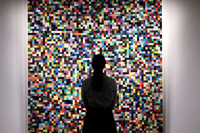 A guest looks at “4096 Farben” by Gerhard Richter during a preview at Sotheby's in New York City, U.S., May 8, 2023. (Photo by Brendan McDermid/Reuters)