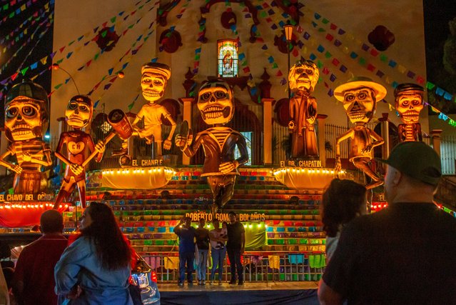 Visitors enjoy day of the dead decorations honouring late Mexican director Roberto Gomez Bolanos outside the cathedral in Santiago, Nuevo Leon state, Mexico on October 29, 2024. (Photo by Julio Cesar Aguilar/AFP Photo)