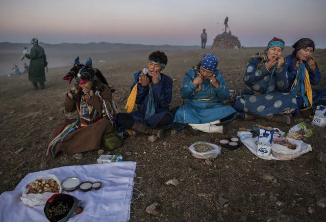 Mongolian Shamans or Buu, play the mouth harp or khel khurr, used to summon spirits, during a sun ritual ceremony to mark the period of the Summer Solstice in the grasslands at sunrise on June 22, 2018 outside Ulaanbaatar, Mongolia. (Photo by Kevin Frayer/Getty Images)