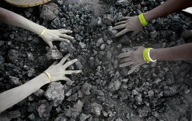 Indian women use bare hands to pick reusable pieces from heaps of used coal discarded by a carbon factory in Gauhati, India, Monday, December 14, 2015. The collected pieces will be reused for cooking food. (Photo by Anupam Nath/AP Photo)