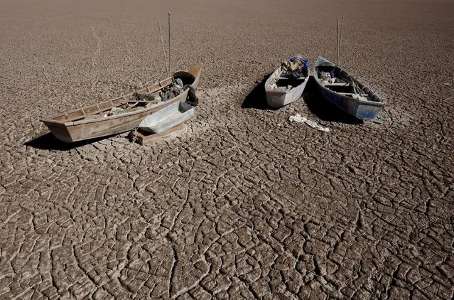Boats of fishermen are seen on the dried Poopo lakebed in the Oruro Department, south of La Paz, Bolivia, December 17, 2015. (Photo by David Mercado/Reuters)