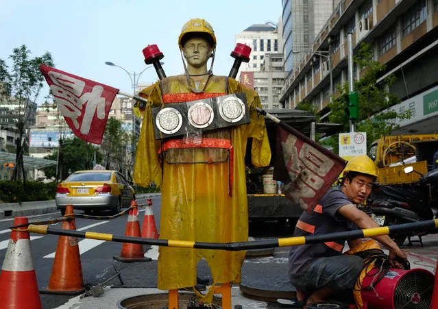 A city utility worker leaves a manhole in Taipei, Taiwan, Tuesday, July 23, 2013. (Photo by Wally Santana/AP Photo)